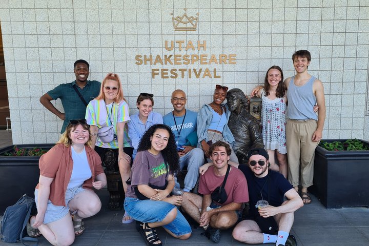 a group of students (acting and technical) smiling in front of Utah Shakespeare Festival sign