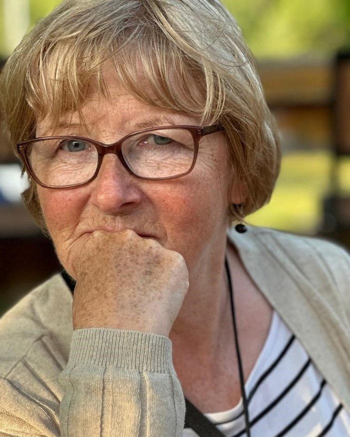 Head and shoulders image of Angela Taylor facing the camera and resting on her forearm.