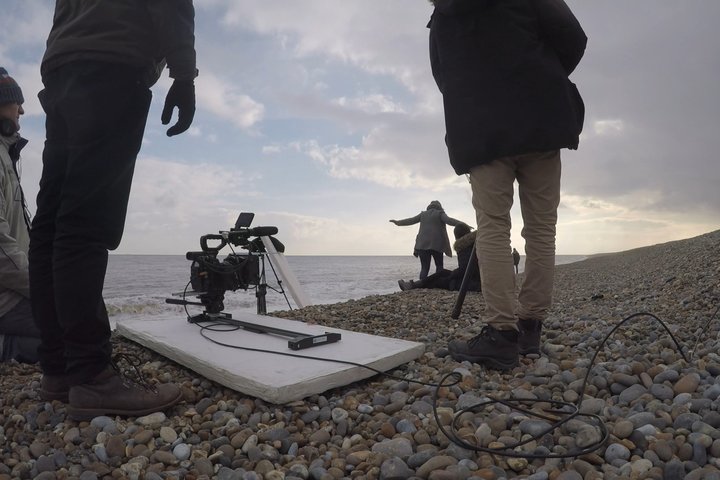 acting and theatre production students filming on location on a pebble beach