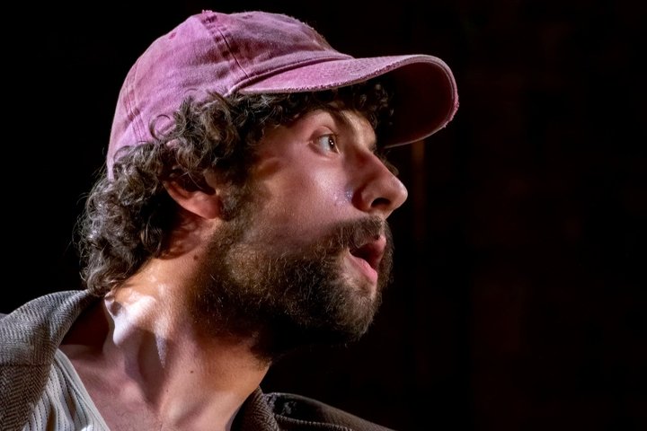 © Linda Carter Close up of Keaton's side profile as he looks right in dramatic lighting while wearing a cap.