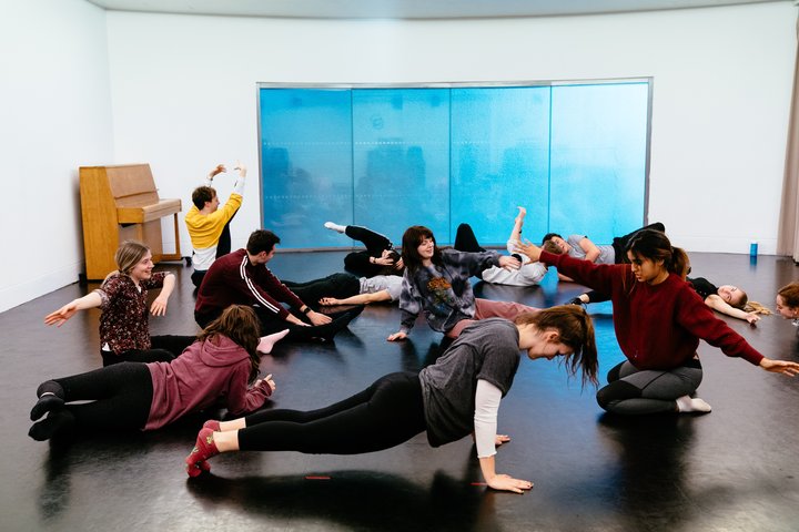 Students rehearse at RADA. They are kneeling or lying on the floor, making shapes with their arms.