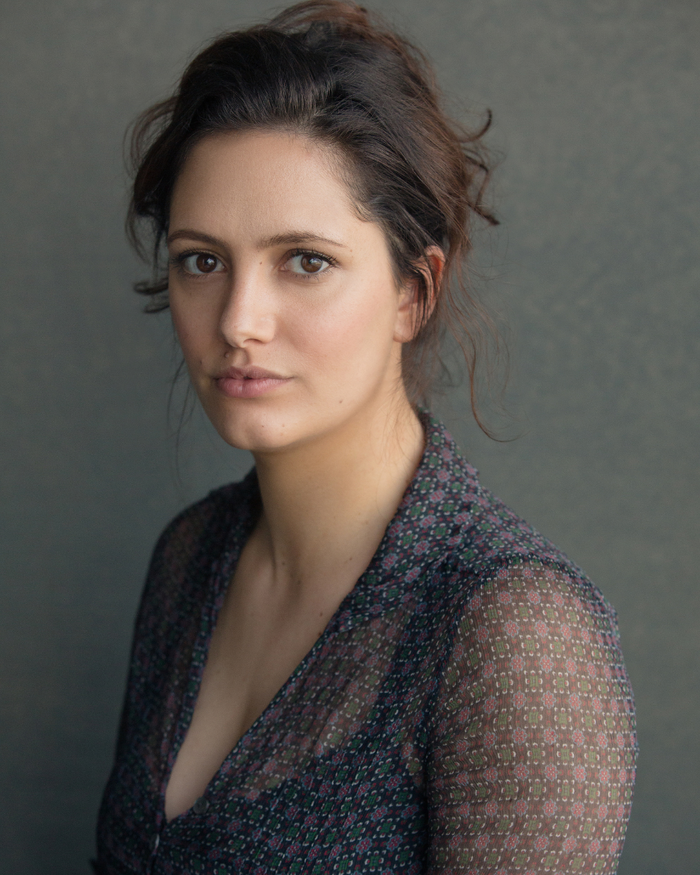 Portrait head and shoulders image of Skye Hallam sitting on an angle, looking into the camera.