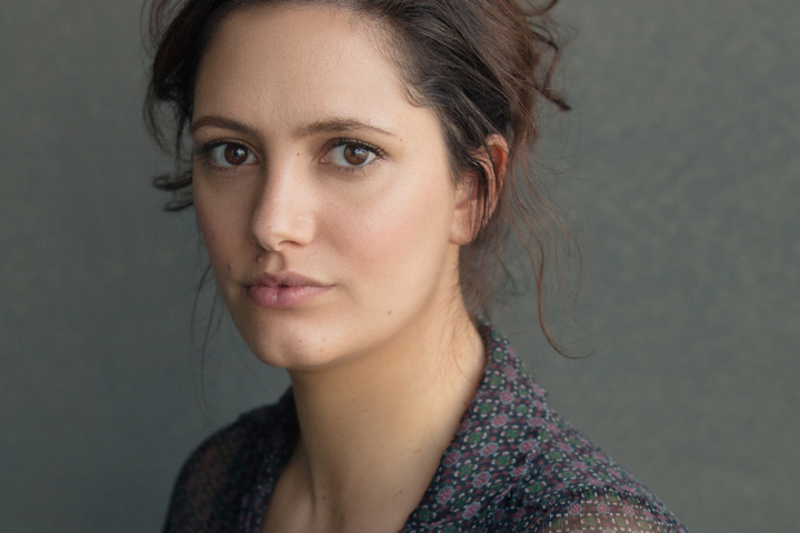 Portrait head and shoulders image of Skye Hallam sitting on an angle, looking into the camera.