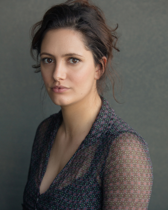 Portrait head and shoulders image of Skye Hallam sitting on an angle, looking into the camera.