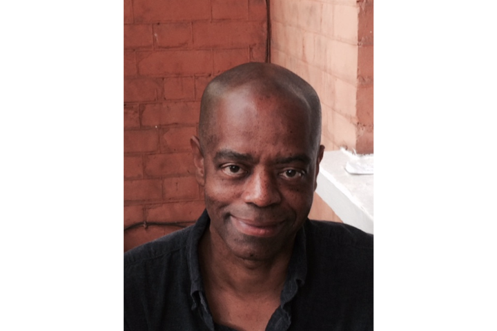 Head and shoulders image of Mike Bryant directly facing the camera in front of red brick and a white windowsill