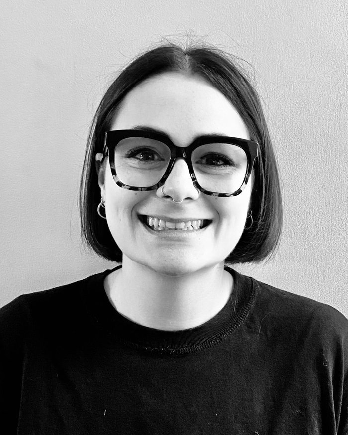 Portrait, head and shoulders image of Vari Pritchard looking directly at the camera, facing front in black and white.