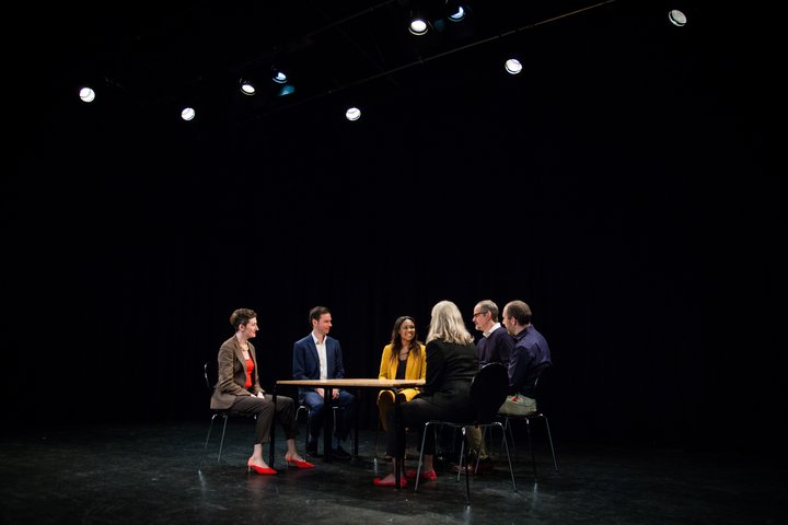 A group  of RADA Business participants take part in a meeting in a theatrical space.