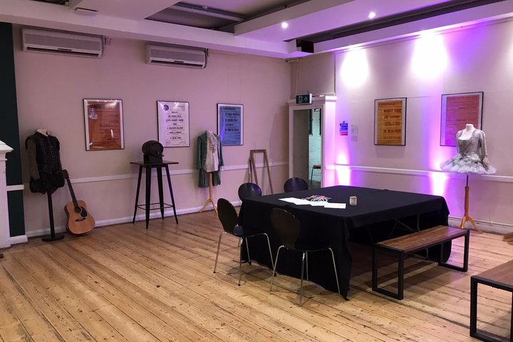Studio Bar set up for an event with three costumes displayed on mannequins and dramatic lighting