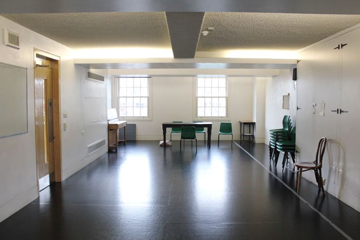 empty Acting Room 2 rehearsal studio with tables, chairs and upright piano