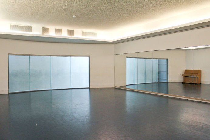 empty B25 rehearsal studio with floor-to-ceiling mirrors and upright piano