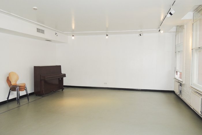 empty Edmund Kean rehearsal studio with stacked chairs and upright piano
