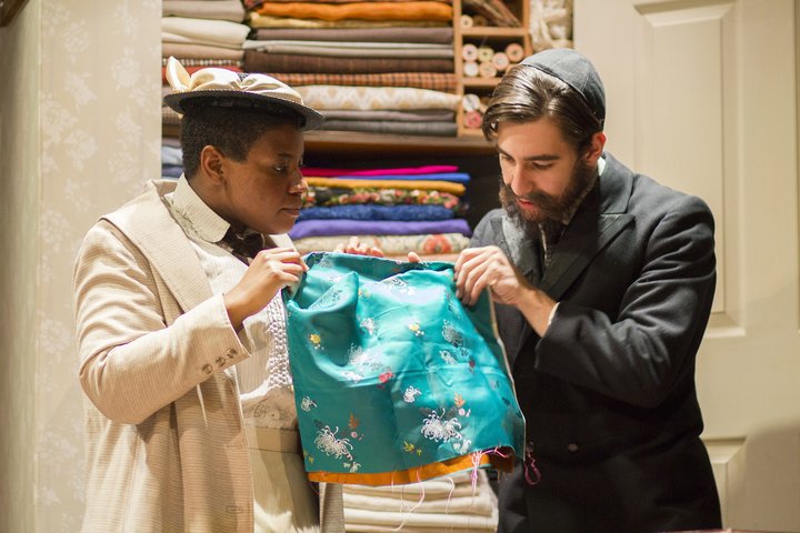 In a scene from Intimate Apparel, two characters admire a piece of vibrant, patterned silk cloth