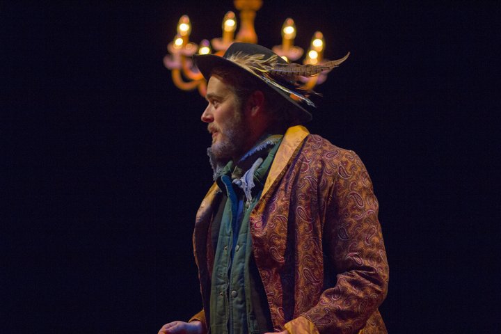 In a scene from Philistines a male character wears a brocade coat feathered hat and turquoise jacket