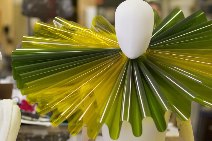 Bright yellow and green acetate ruff on model in workshop
