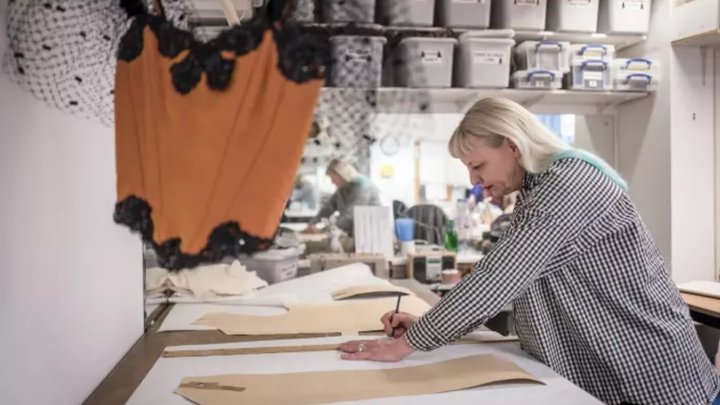 student Reny Morsch cuts a pattern in the costume workshop