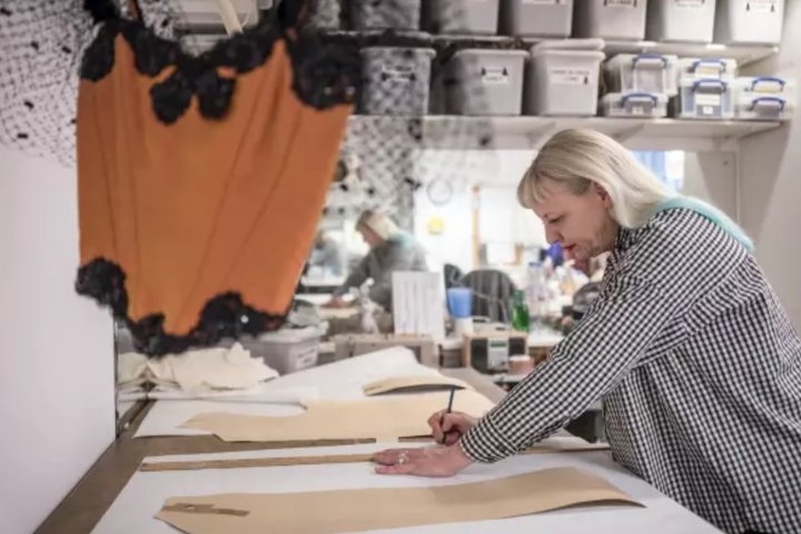 student Reny Morsch cuts a pattern in the costume workshop