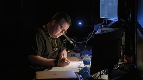 A stage manager works in dark lighting during a performance
