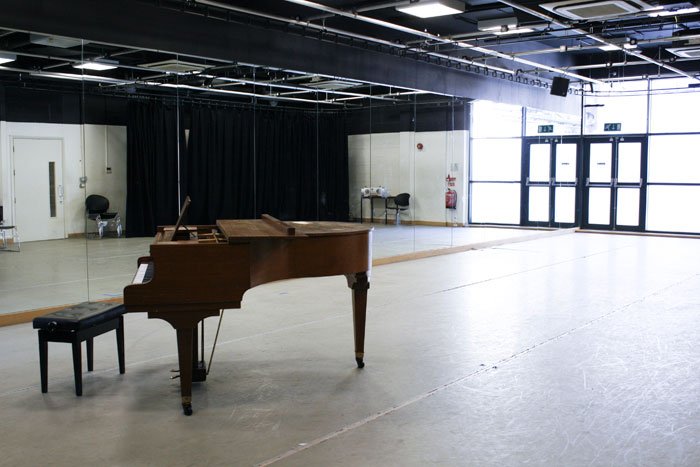 empty Squire Bancroft studio with floor-to-ceiling mirrors and piano
