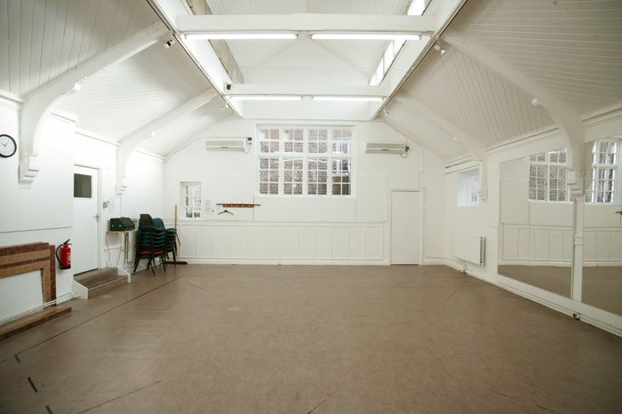 empty studio 2 room with stacked chairs and large wall mirrors