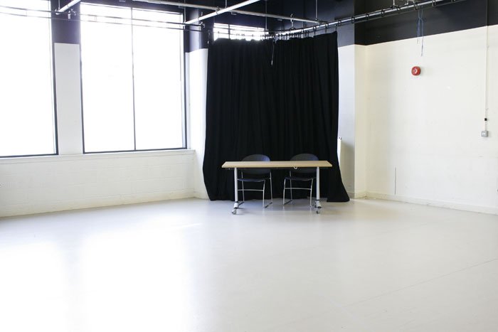 empty Wolfson Gielgud studio with table, chairs and pulled back curtain